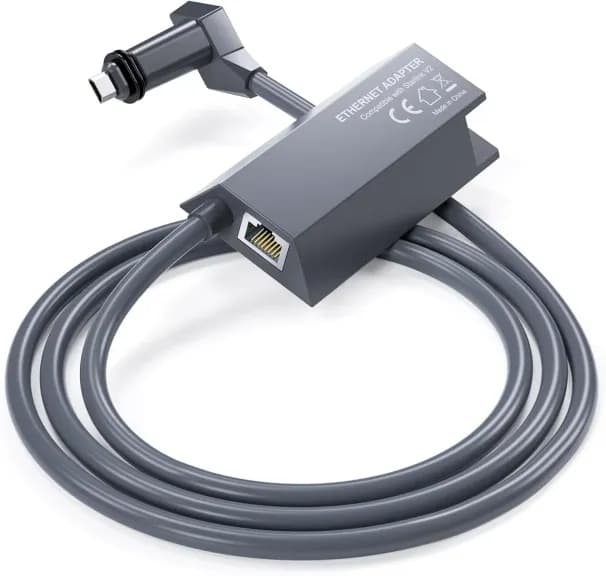 Starlink ethernet adapter, a grey inline module with an RJ45 socket, its cable coiled beneath it.